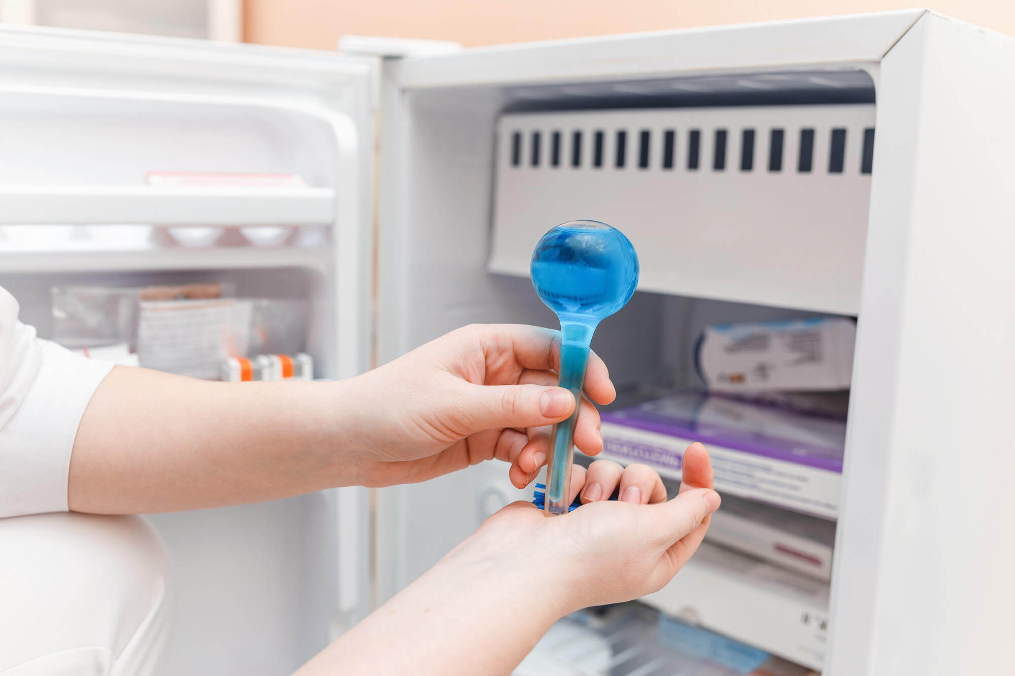 Technician checking laboratory freezer temperature